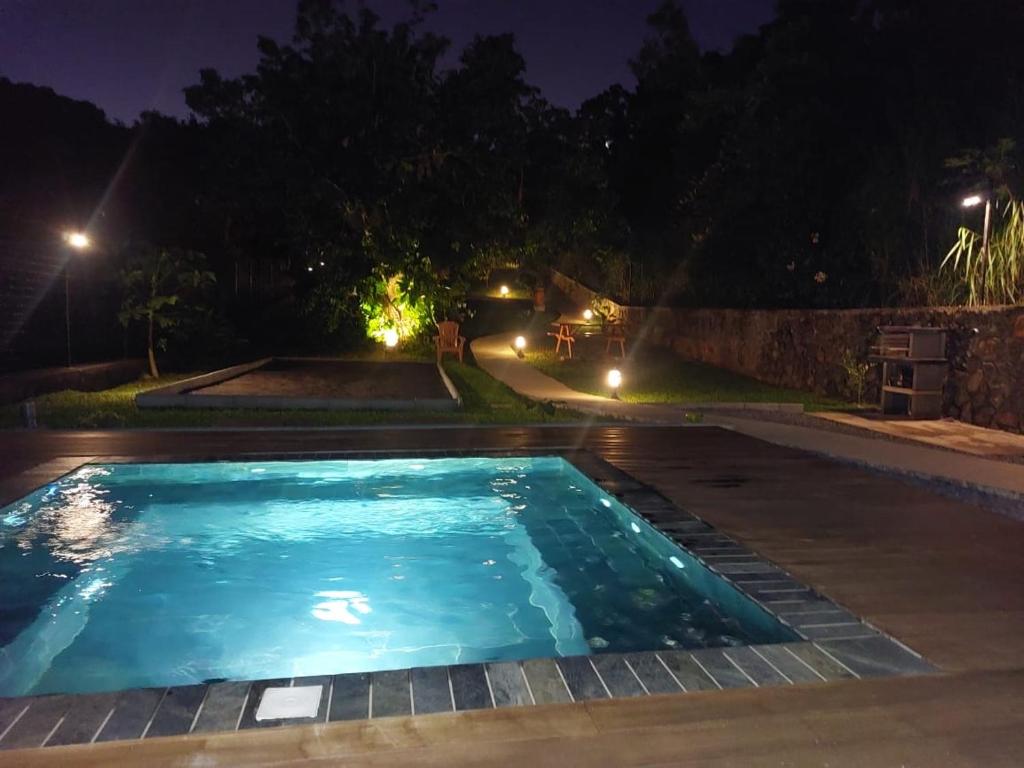 una piscina en un patio por la noche en Austral House-chalet sud sauvage en Saint-Joseph