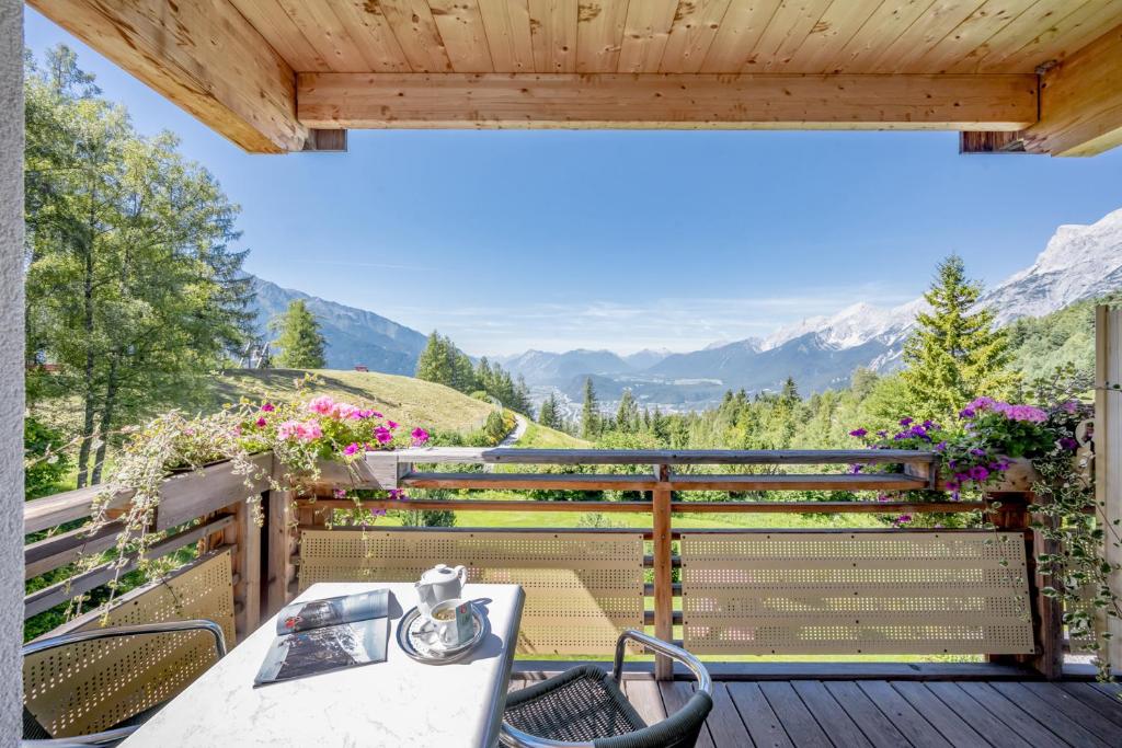 einen Tisch und Stühle auf einer Terrasse mit Aussicht in der Unterkunft Inntaler Hof in Seefeld in Tirol
