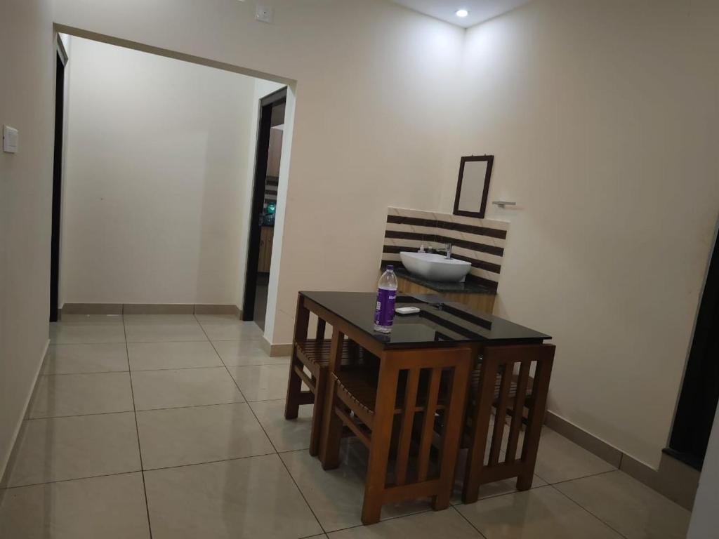 Habitación con mesa, sillas y puerta. en Alora vrindhavan villa, en Meppādi