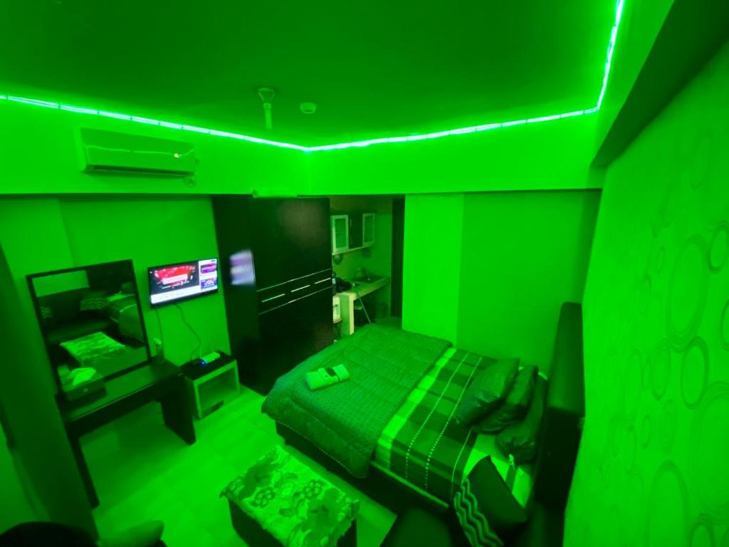 uma sala verde com uma cama e uma televisão em APARTEMEN MARGONDA RESIDENCE 3 DEPOK By DBancah Rooms 719 em Kemirimuka Tiga