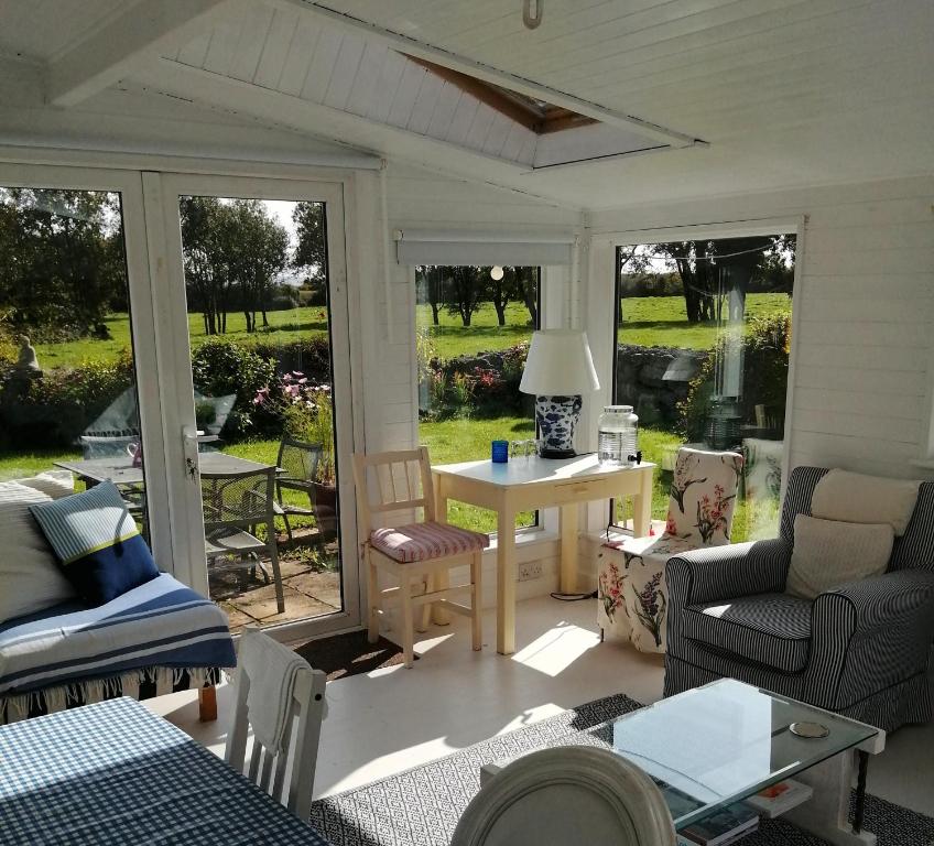 un porche cubierto con mesa y sillas en Quaint secluded Cottage close to beautiful Kinvara, en Gort
