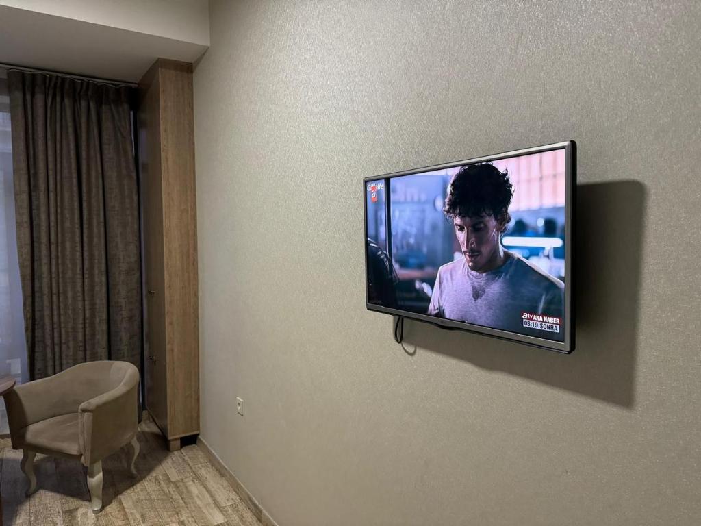 a flat screen tv hanging on a wall at Гостиница Низами Стрит in Baku