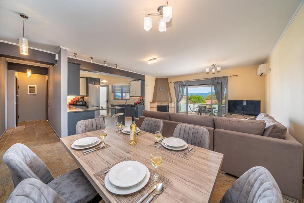 a dining room with a table and a couch at Nicolis Seaside Apartment in Karavomylos