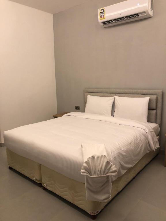 Iveria Hotel Apartments في هيل العمير: غرفة نوم بسرير مع مكيف على الحائط