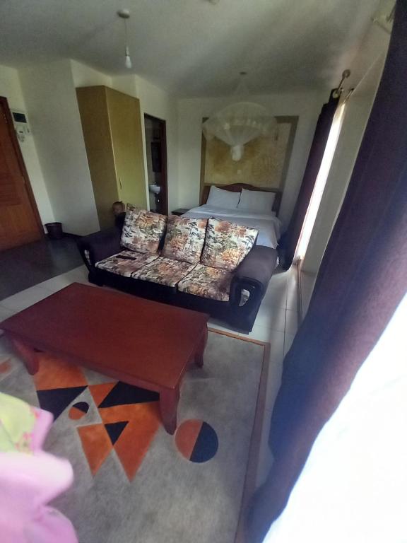a hotel room with a bed and a couch at Best suites ngara in Nairobi