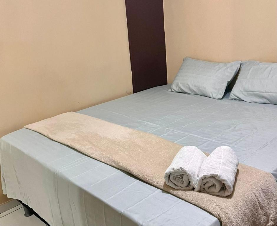 a bed with two towels sitting on top of it at Hotel Santiago Juazeiro in Juazeiro do Norte