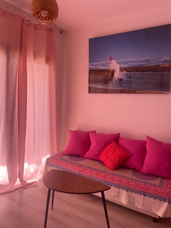 un soggiorno con divano e cuscini rosa di Ático con terraza, piscina y jacuzzi a Villanueva de Río Segura
