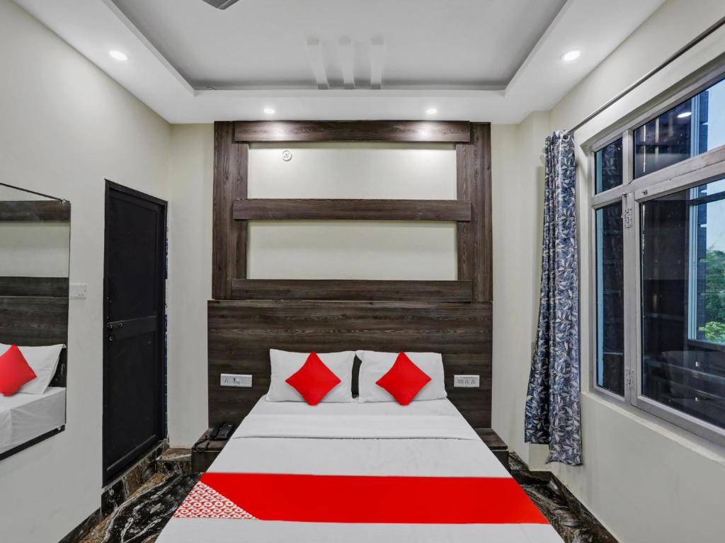 - une chambre avec un lit doté d'oreillers rouges et une fenêtre dans l'établissement OYO Flagship 80984 Hotel Siddhi Vinayak, à Kanpur