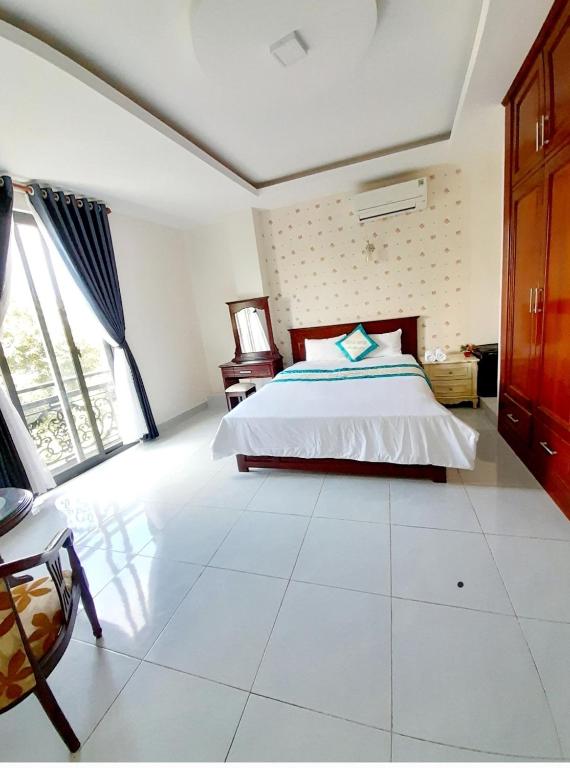 a bedroom with a bed and a large window at HOTEL VIỆT ÚC, H17 Phan Huy Chú, phường Vũng Tàu in Vung Tau