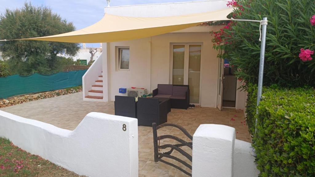 a patio with a chair and an umbrella at Chalet Calan Bosch in Cala en Bosc