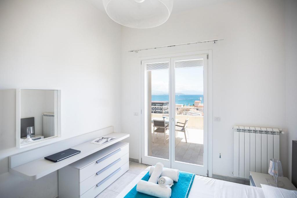 a white bedroom with a view of the ocean at Suite vista mare in Gaeta