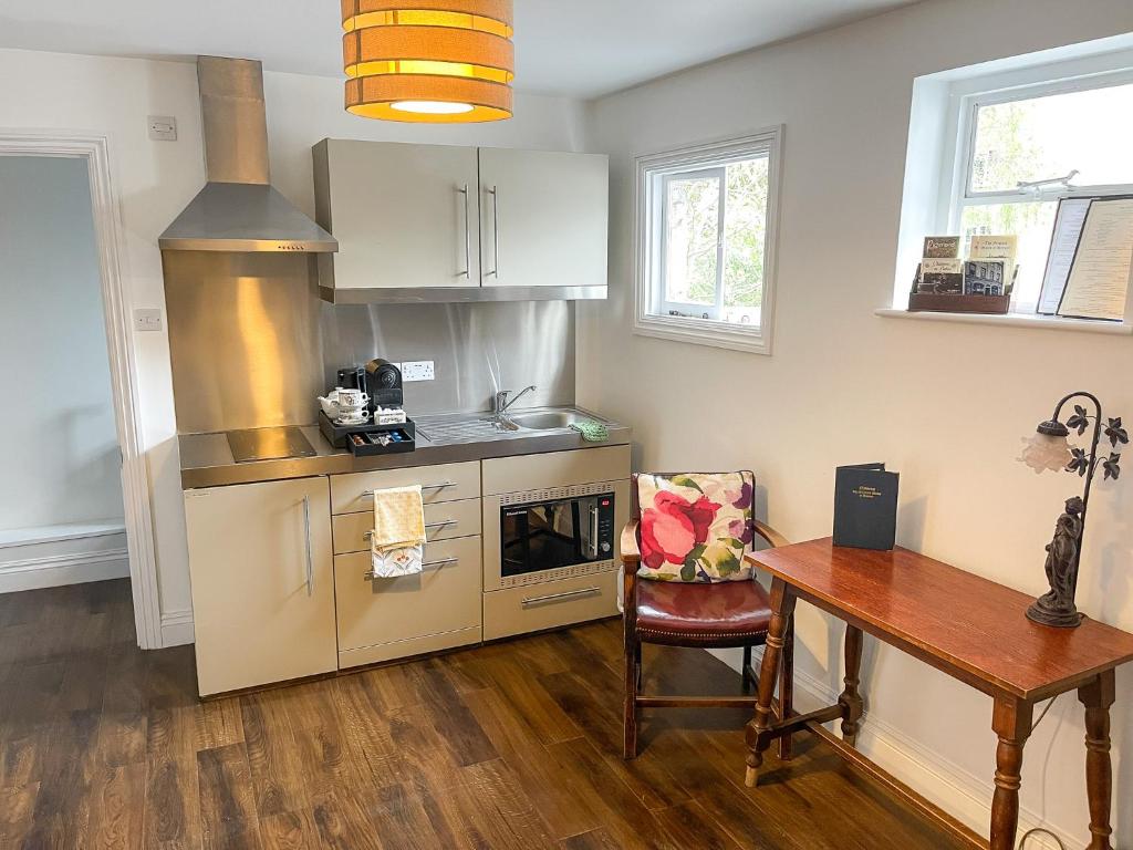 a kitchen with a wooden table and a table and a table at Maids Guest Rooms in Kew