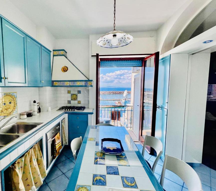 eine Küche mit blauen Schränken und einem Tisch mit Stühlen in der Unterkunft Aqua Blu Apartment Stella Maris in Piano di Sorrento