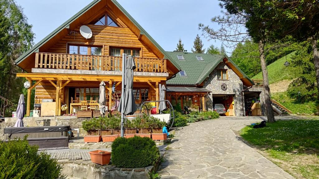 una casa di tronchi con un sentiero che conduce a quella di Chata nad stawem a Wierchomla Mała