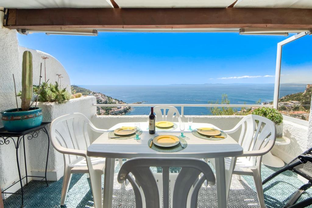 een witte tafel en stoelen op een balkon met uitzicht bij Ibiza Bramer 11 Canyelles Roses - Barneda in Roses