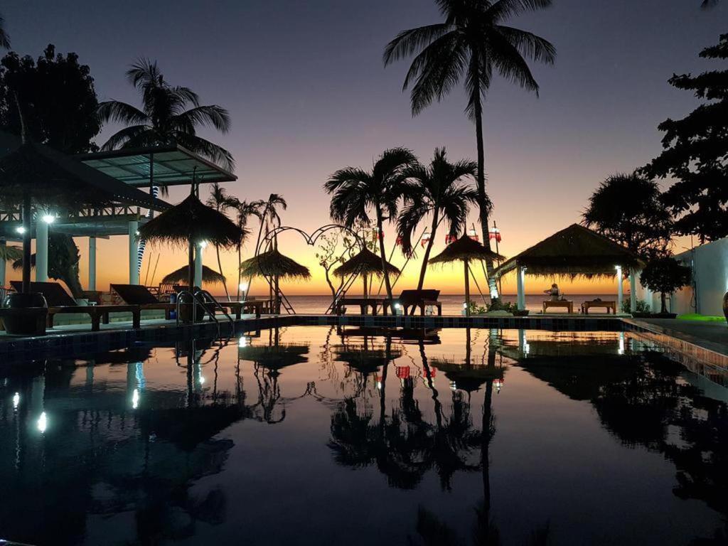 una piscina con sombrillas y el océano al atardecer en Stunning 1-Bed Chalet in El Pillax Resort ko lanta en Phra Ae beach