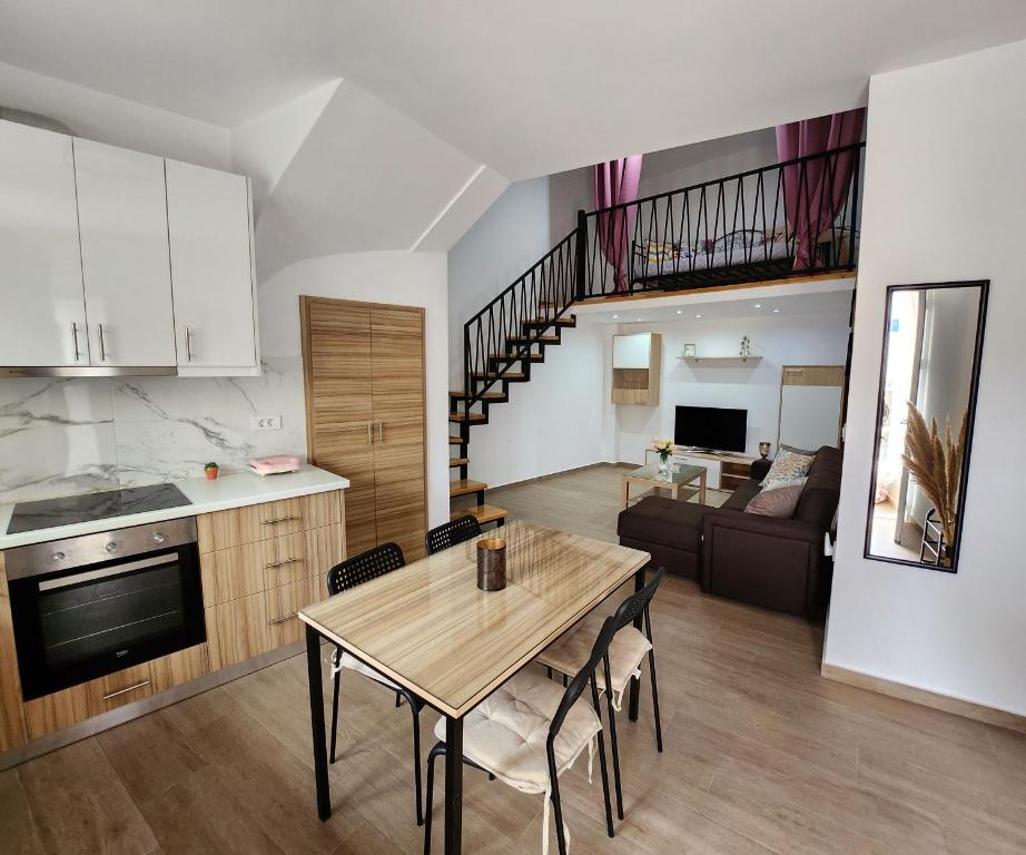 uma cozinha e uma sala de estar com mesa e cadeiras em Loft Apartment in Kos em Kefalos