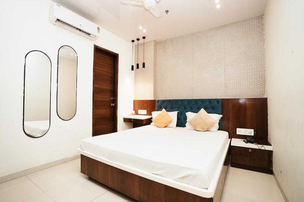 1 dormitorio con 1 cama grande y 2 espejos en Hotel Elegance, en Bombay