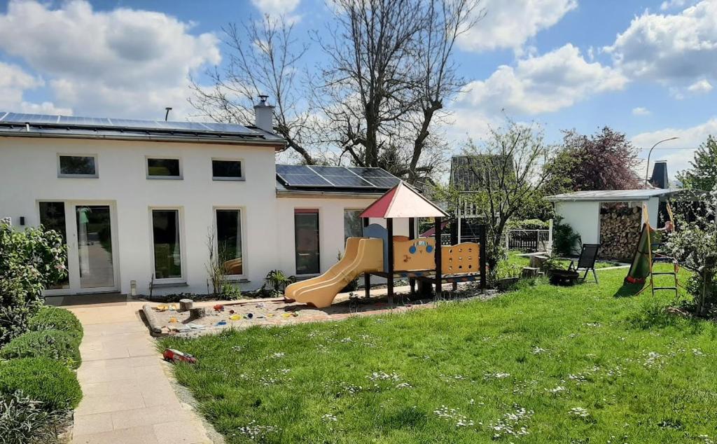 a yard with a playground in front of a house at Chalet im Spiel- und Obstgarten in Keidelheim