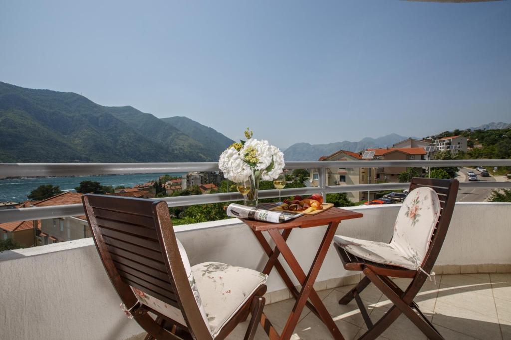 a balcony with two chairs and a table with flowers at Soul of the Kotor Bay in Dobrota