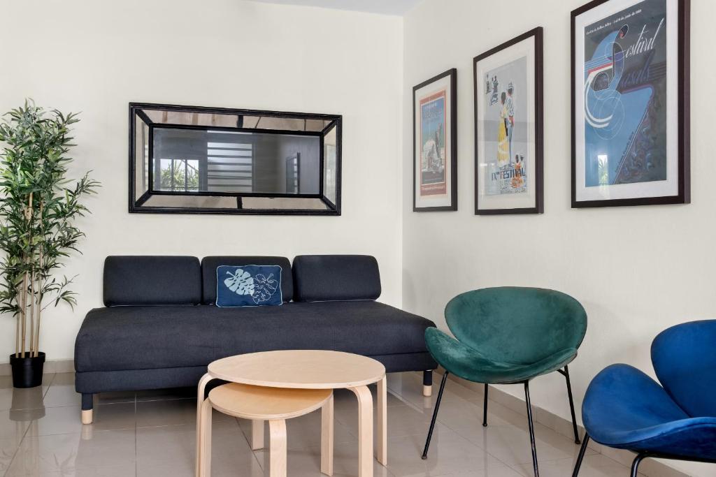 un soggiorno con divano e 2 sedie di Prime Location at Condado Beach 1br 1 ba - Apt 7 a San Juan