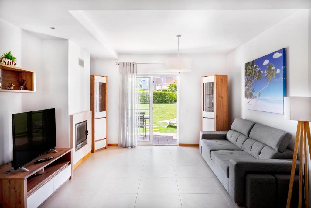 a living room with a couch and a television at Apartamento no Condomínio Baia Village com Piscina in Albufeira