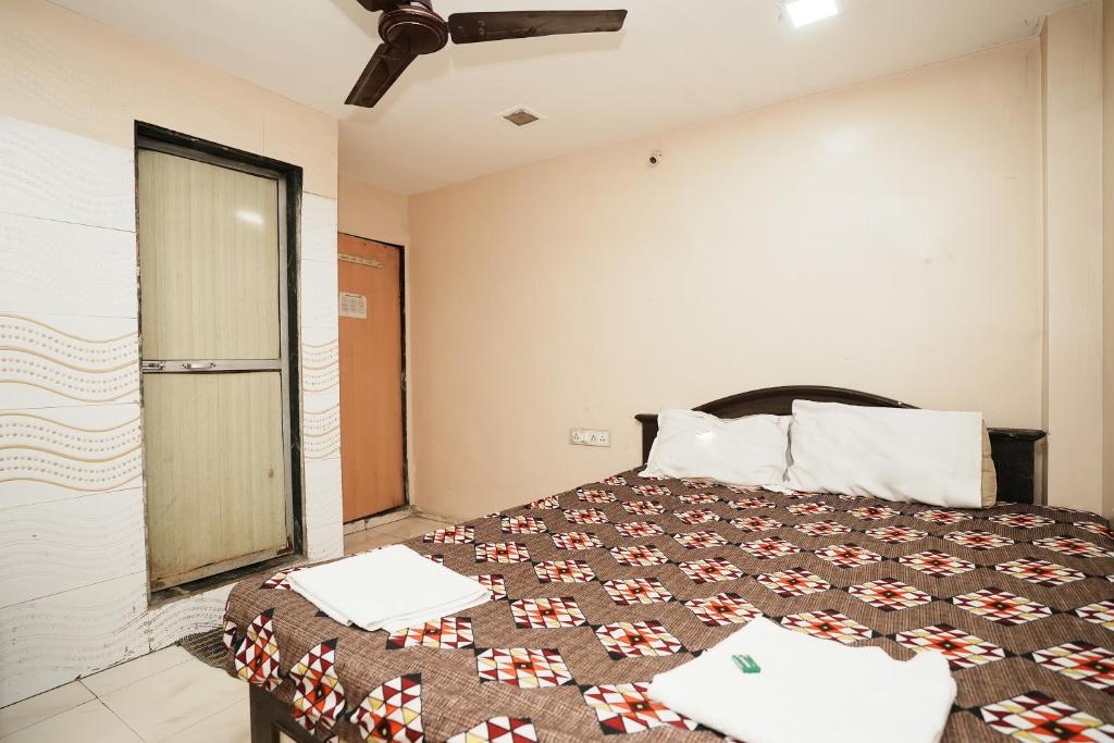 Harihara Residency في مومباي: غرفة نوم مع سرير وبطانية بنية وبيضاء