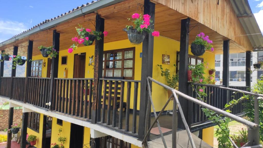 a yellow building with flowers on the balcony at Hotel Brisas del Nevado in Güicán