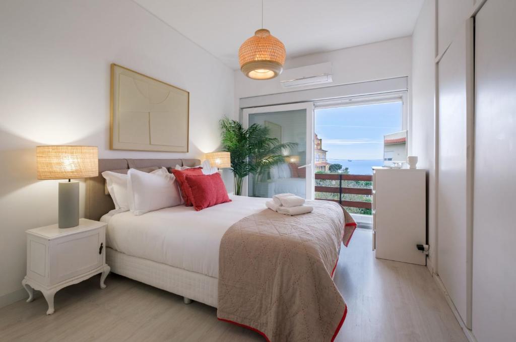 um quarto com uma cama e uma grande janela em Portugal Portfolio - Seascape Apartment Unit 1 em Estoril