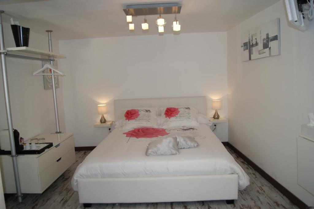 um quarto com uma cama branca com rosas vermelhas em B&B Villa Castelnau Montpellier em Castelnau-le-Lez