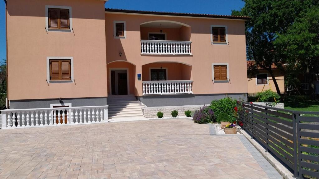 a large house with a fence in front of it at Apartmani Marica in Plomin