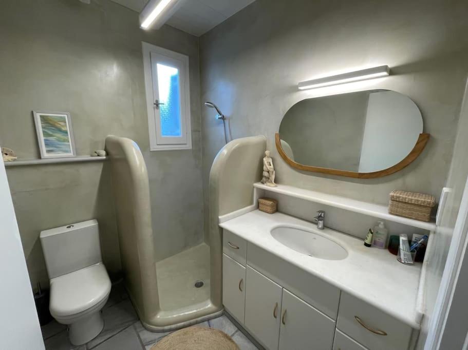 een badkamer met een wastafel, een toilet en een spiegel bij Stylish Cycladic Family Villa with Private Gardens - Villa Botanica in Kampos Paros