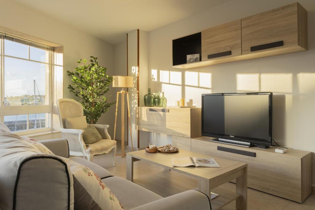 ein Wohnzimmer mit Fernseher und Sofa in der Unterkunft Bleumaison-a mariña portonovo in Portonovo