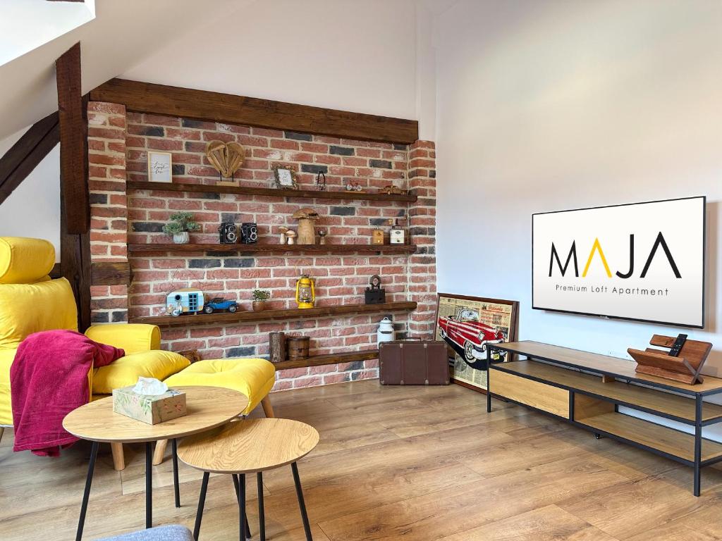 a living room with a couch and a brick wall at MAJA Premium Loft Apartment in historical city center in Komárno