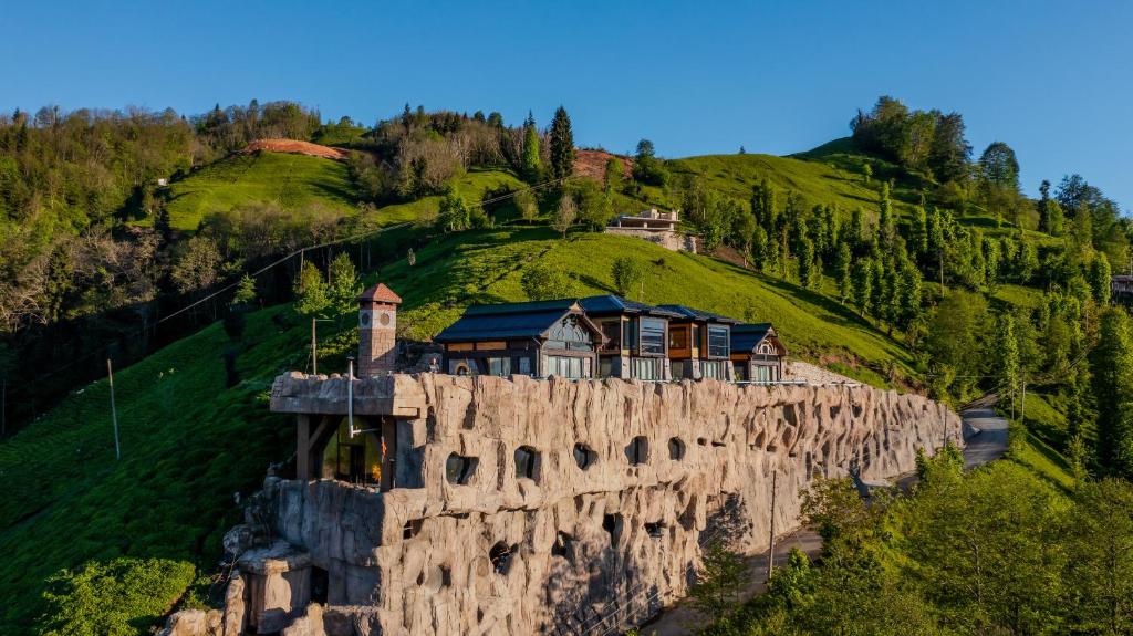 une maison au sommet d'une falaise rocheuse dans l'établissement Amazena, à Çamlıhemşin