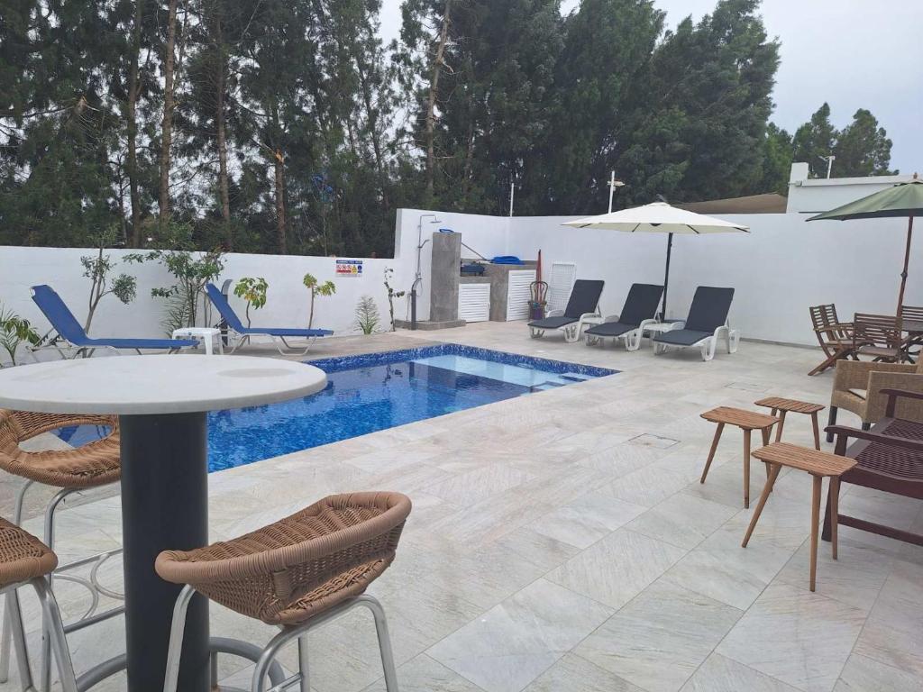 um pátio com uma mesa e cadeiras e uma piscina em LaVa Villa em Agia Napa