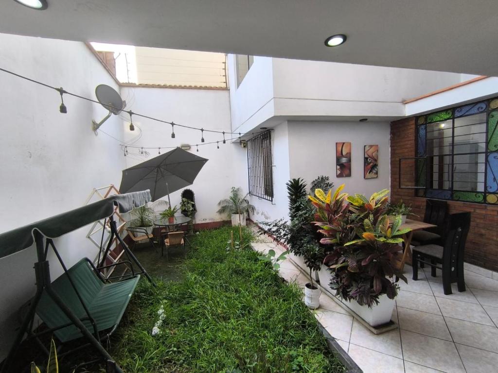 patio ze stołem, parasolem i roślinami w obiekcie Sumaq Wasi Caminos Del Inca w mieście Lima