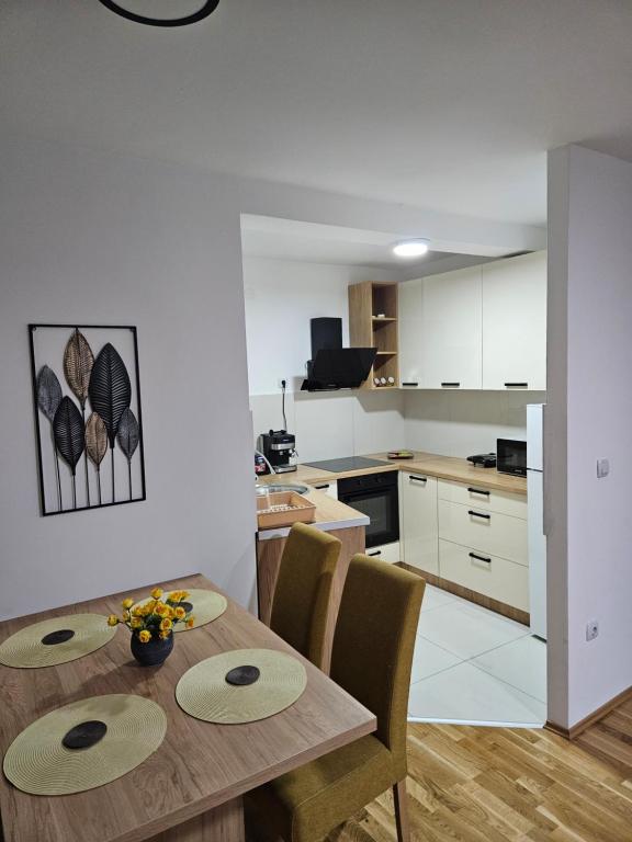 a kitchen and dining room with a wooden table and chairs at N&M Apartment in Pirot