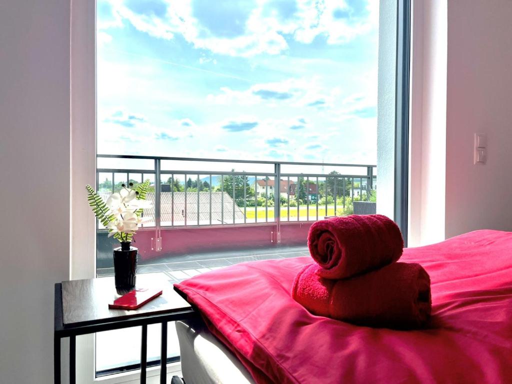 a teddy bear sitting on a bed in front of a window at Weißes Haus in Gerasdorf bei Wien