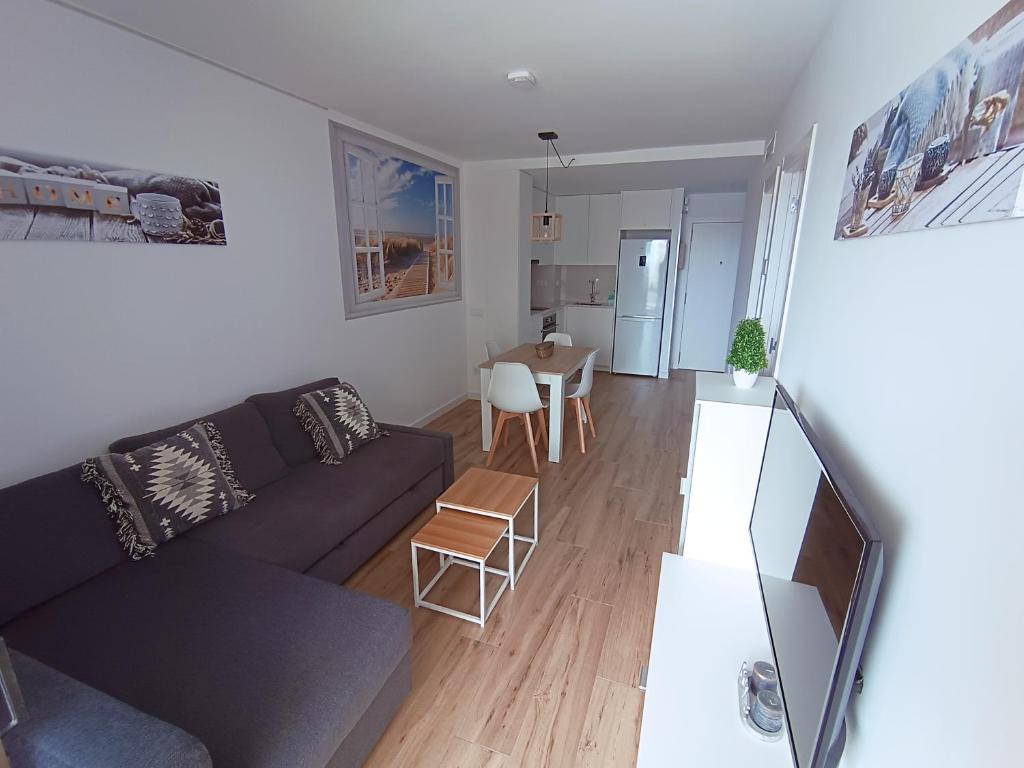 a living room with a couch and a table at Apartamento nuevo en Calella totalmente reformado con Parking privado in Calella