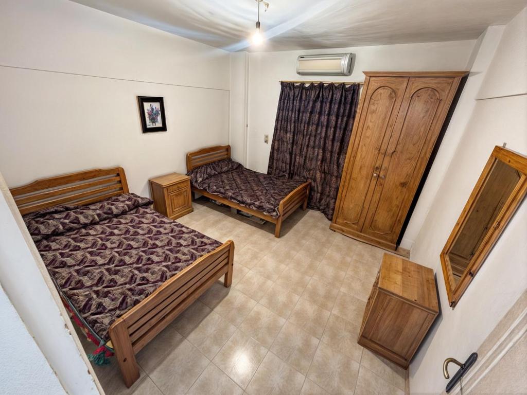 a small bedroom with two beds and a cabinet at شاليه قرية المنال ٢ in Ain Sokhna