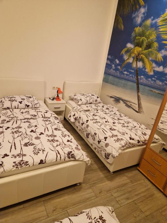 2 camas en un dormitorio con un mural de playa en Sobe - Nova Gradiška smještaj Auto Klarić, en Nova Gradiška