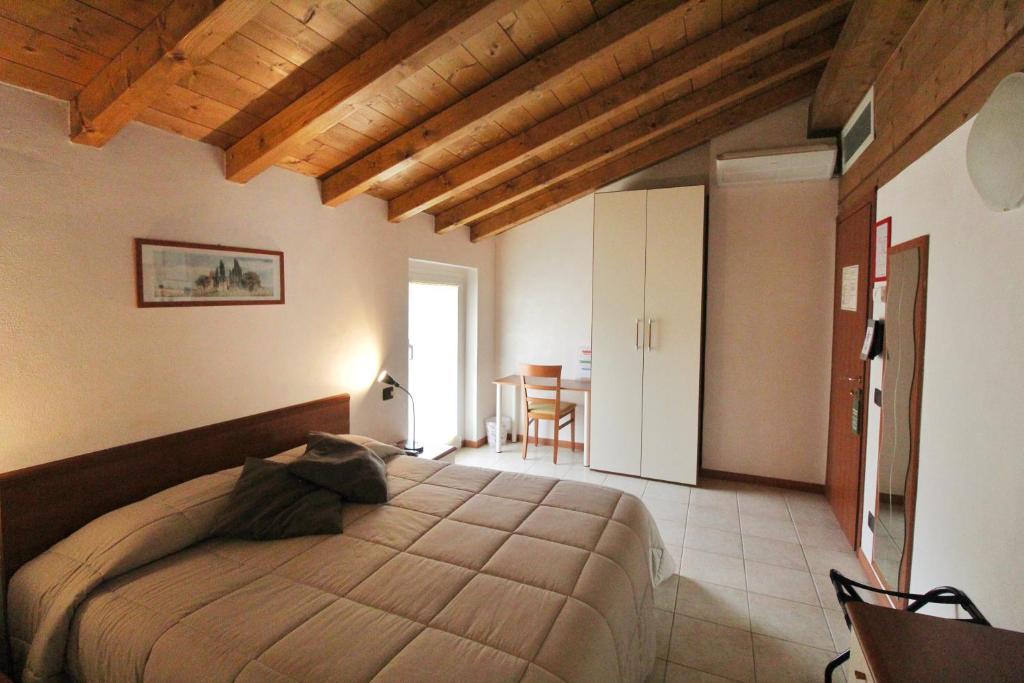 una camera con un grande letto e un tavolo di Hotel Avogadro a San Pellegrino Terme