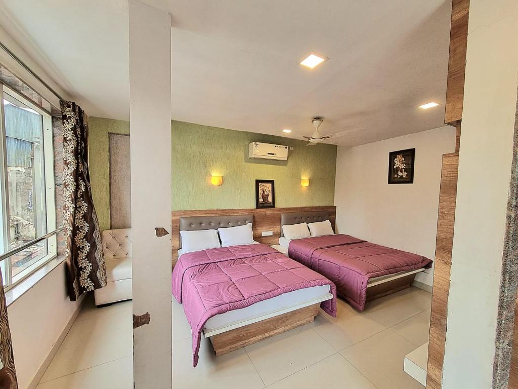 1 dormitorio con 2 camas y ventana en City pride family en Mahabaleshwar