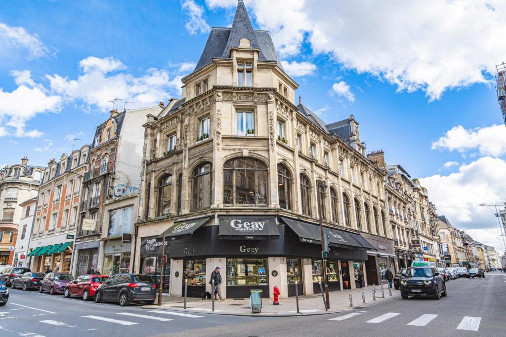 un bâtiment dans une rue de la ville avec des voitures garées dans la rue dans l'établissement Aux Clefs des Sacres - Le Talleyrand, à Reims
