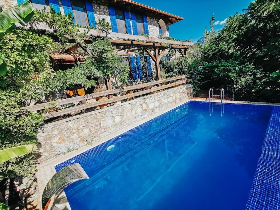 a swimming pool in front of a house at Orman İçinde Muhteşem Villa in Kayakoy