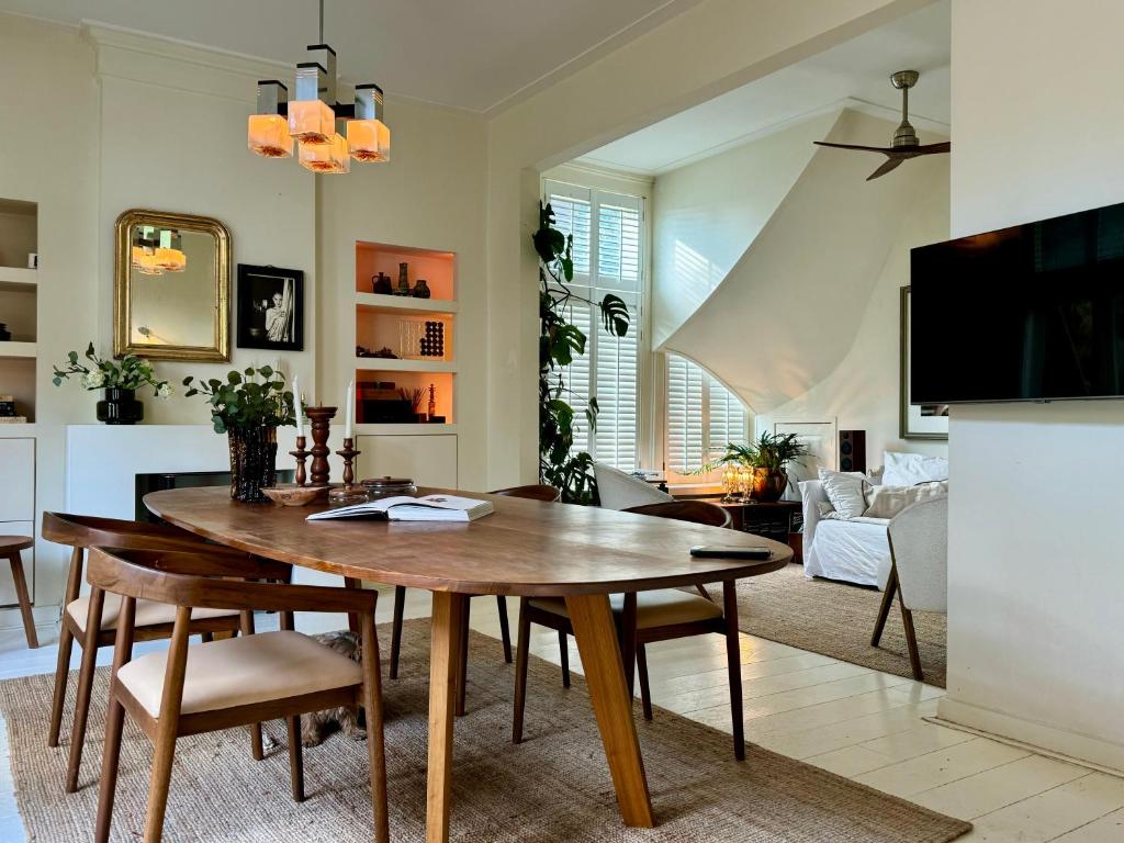 een keuken en een woonkamer met een houten tafel en stoelen bij WS77 Appartment in Leiden
