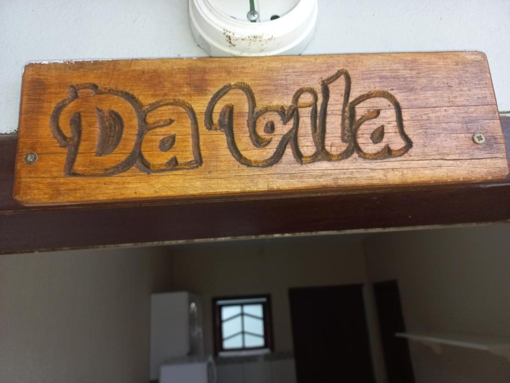 una señal que dice daria en la parte superior de una habitación en Pousada Belas Praia quarto Praia da Vila, en Imbituba
