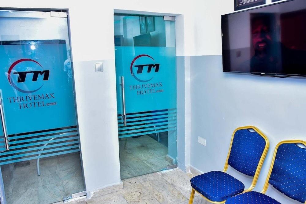 two blue chairs in a room with a window at THRIVEMAX HOTEL AND SUITE in Lagos
