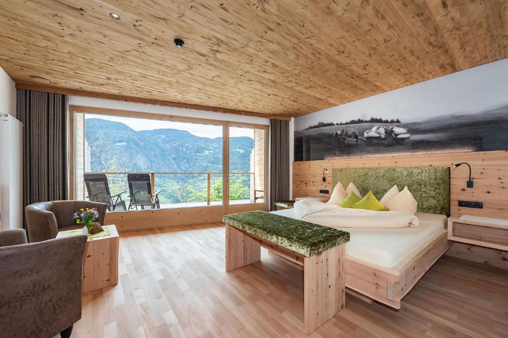 - une chambre avec un lit et une grande fenêtre dans l'établissement Luxury and Nature House Moarlhof, à Castelrotto